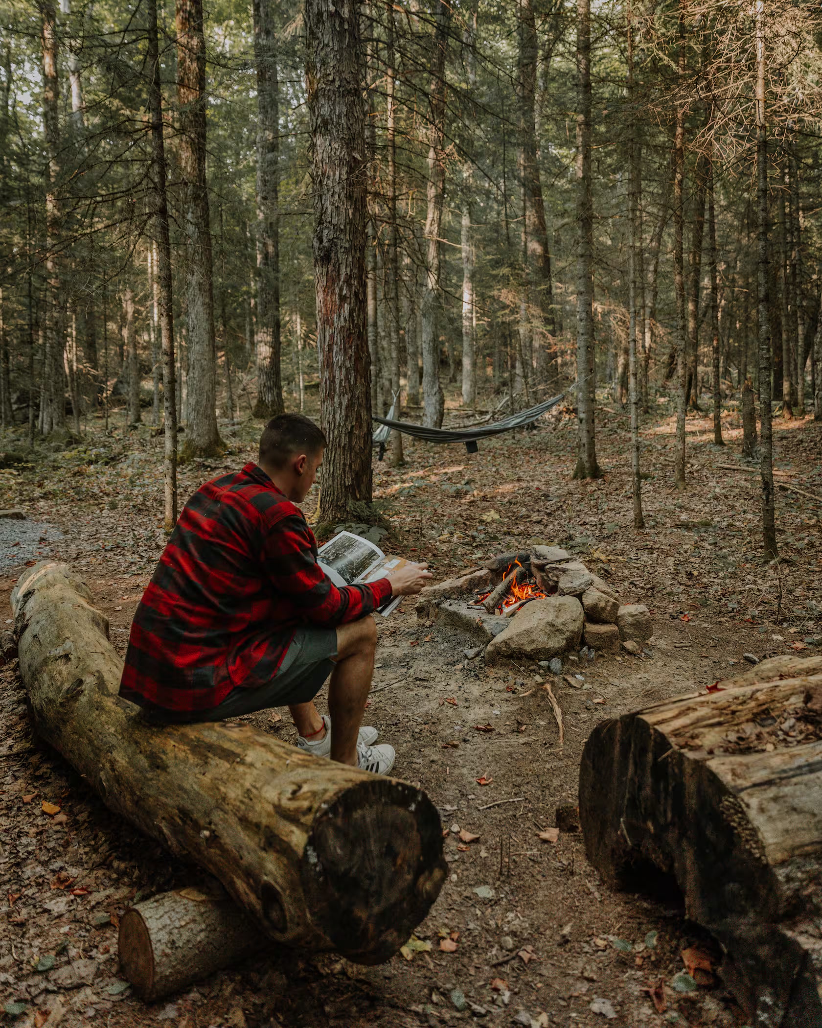 Guest reading beside the forest fire pit