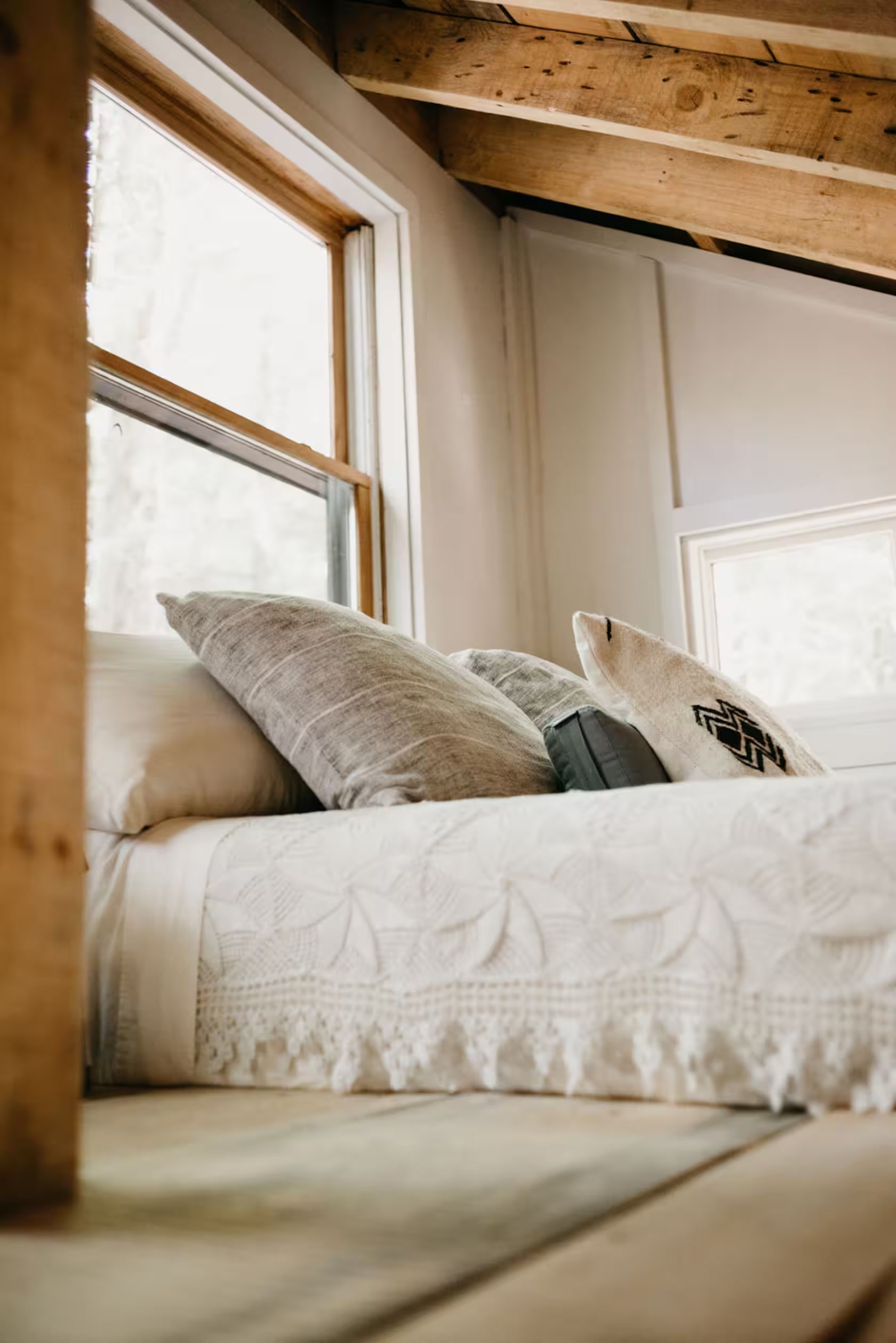 Loft bed beneath exposed wood rafters